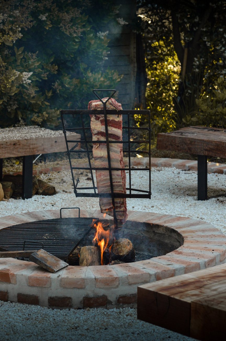 Fogonero de ladrillo con costillar al asador en un jardín
